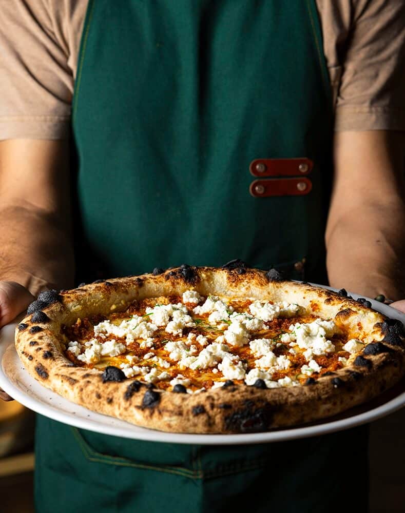 A man holding Aperitivo pizza